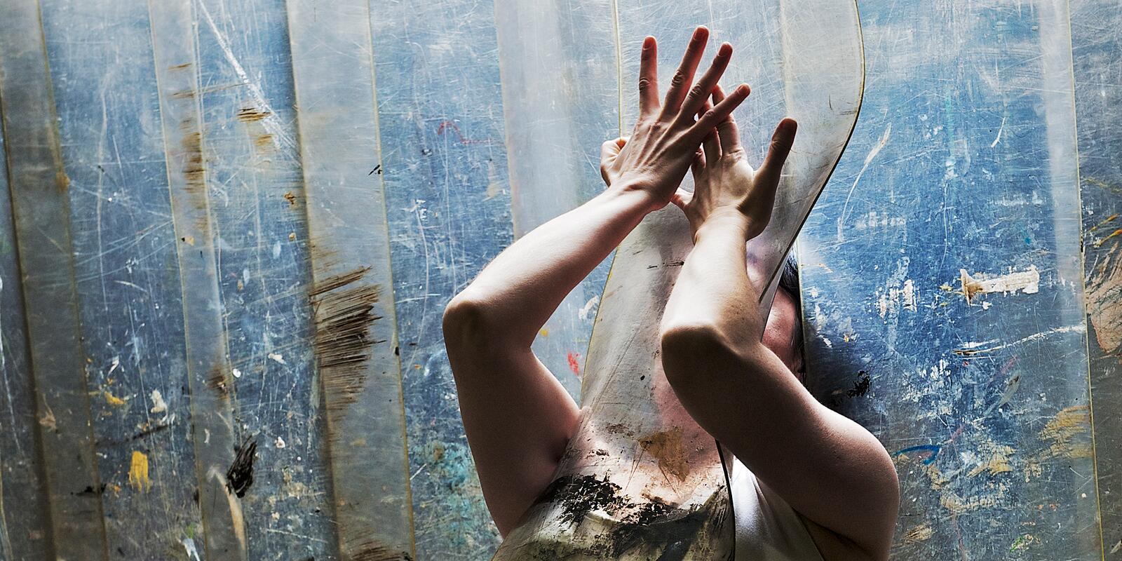 A figure in movement through a curtain of heavy plastic