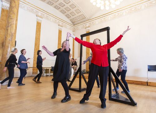 Participants dancing through a freestanding door frame