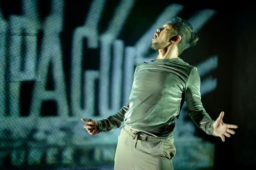 Donking Rongavilla in movement with projections cast on the wall behind him