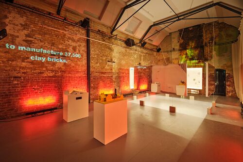 Models on podiums lit red in the CoisCéim studio with exposition panels hanging in the background