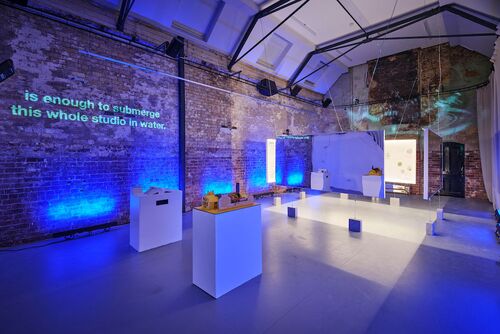 Models on podiums in the CoisCéim studio with exposition panels hanging in the background