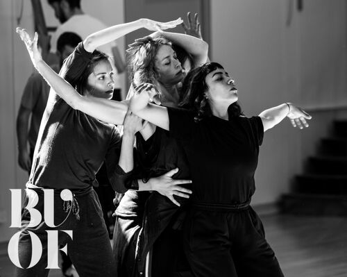 Four figures intertwined in movement in black and white