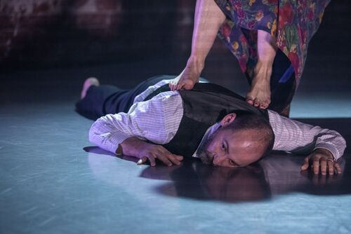 Jonathan Mitchell lying on his front on the floor with feet walking over his back