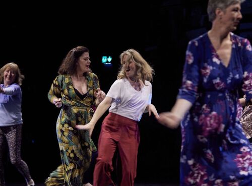 Participants in movement on a dark stage