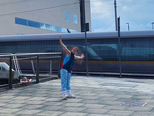 Jessie Thompson in movement at Spencer Dock as a Luas passes