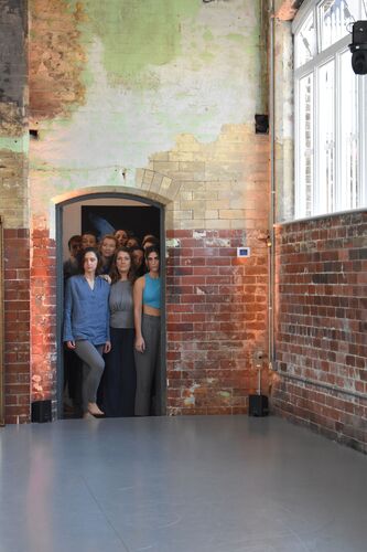 Participants standing in a cluster in the doorway of the CoisCéim studio looking in