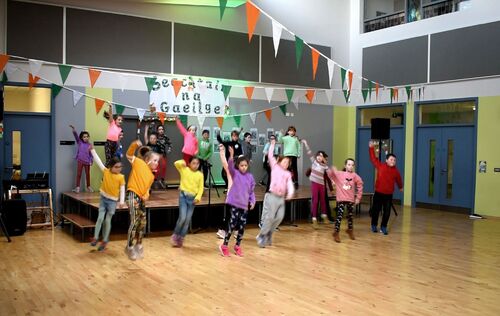 A group of children performing dance in a school hall
