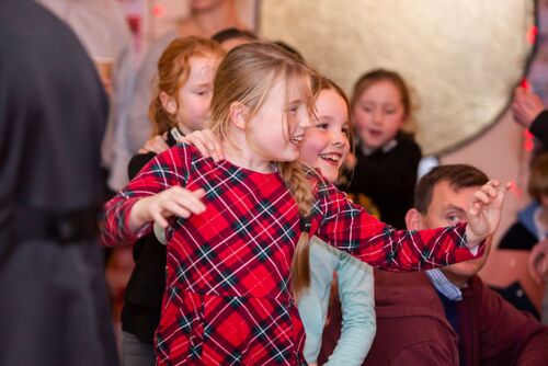 Young participants dancing and laughing in a single file line