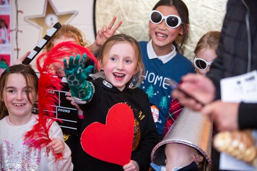 Young participants dressed with various props posing in front of a screen