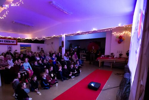 Audience seated in front of a large screen