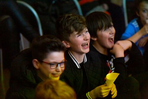 Young participants laughing in the audience of a screening