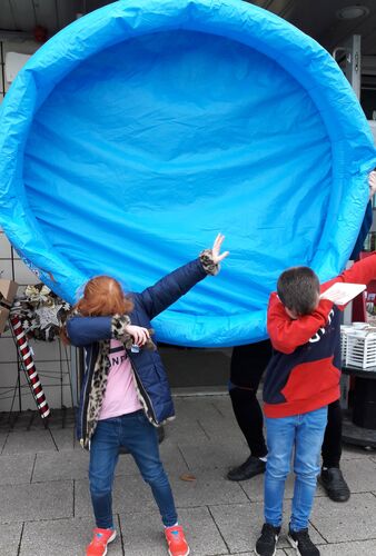Two children dabbing in front of an inflatable blue pool