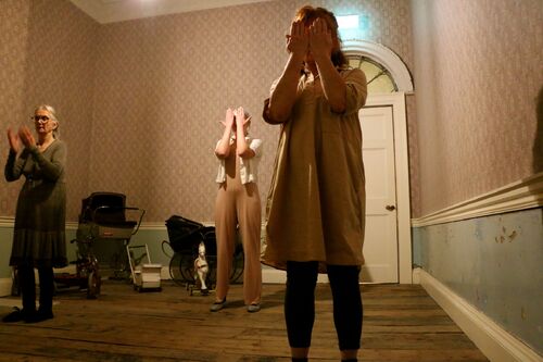 Figures in movement covering their eyes with their hands