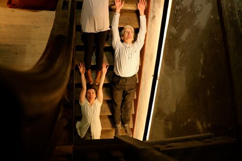 Figures lying spread along a staircase