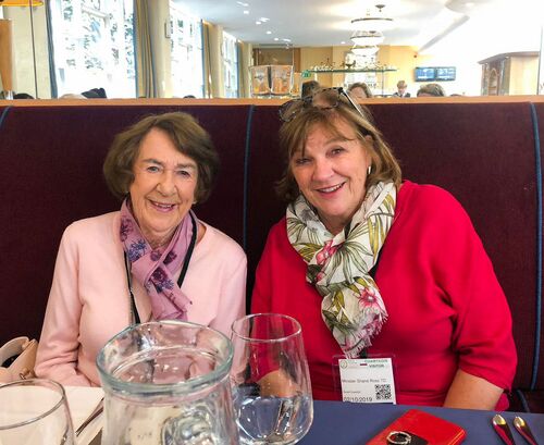 Two participants seated and smiling to camera