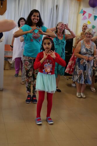A group of people of mixed ages standing and dancing