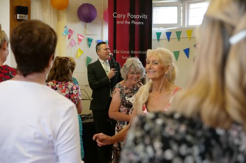 Figures dancing with a singer standing at a microphone in the background