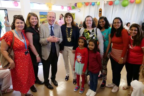 A group of people standing in a line and smiling to camera