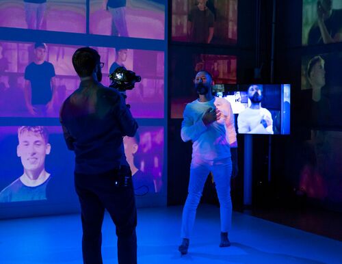 Jonathan Mitchell in movement in front of a screen showing his movements live as he is filmed