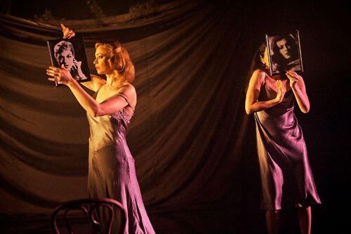 Two figures holding black and white headshots over and in front of their faces