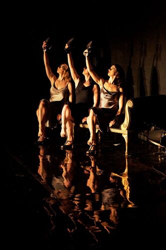 Three figures in movement seated on a chez longue