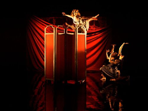 A figure being held aloft above a screen with two other figures in movement to the side