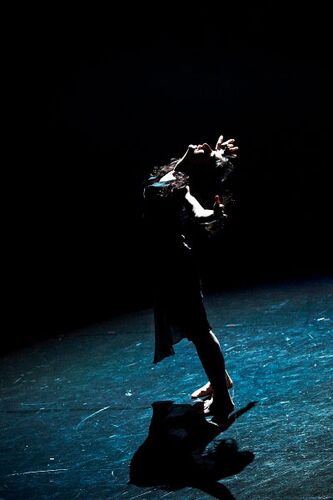 A figure leaning backwards with arms outstretched