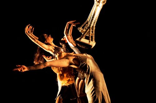 Three figures leaning backwards as swings pass over their torsos