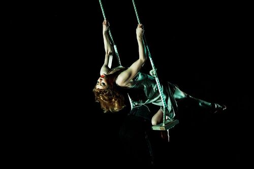 A figure leaning back on a swing