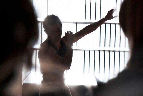 A figure in movement backlit in a window alcove