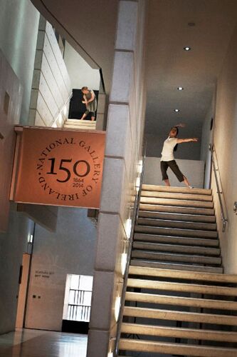 Two figures in movement at the top of two separate flights of stairs