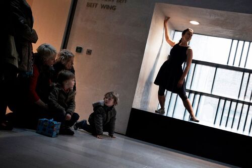A figure in movement in a window alcove in front of audience