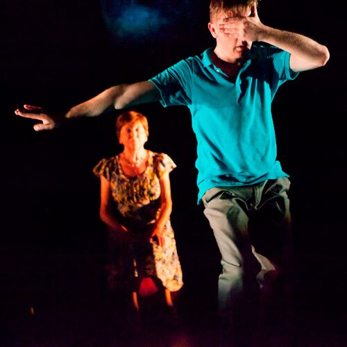 One figure with an arm outstretched and other hand over his face with another figure sat behind