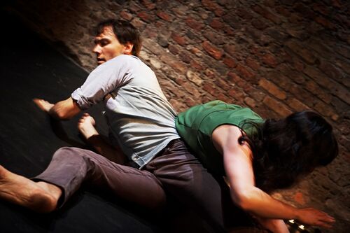 Two figures in movement on the floor
