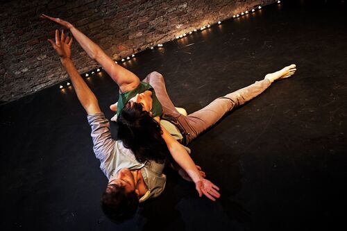 Two figures in movement on the floor