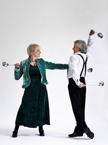 Two figures dancing together both with ladles in each hand