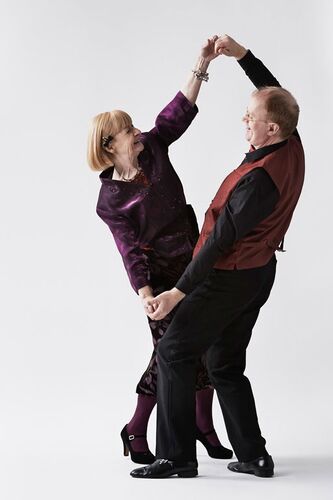 Two figures dancing together holding hands