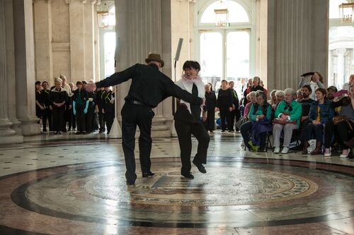 Two participants performing a duet with audience seated around
