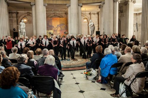 A large ensemble of participants performing for a seated audience