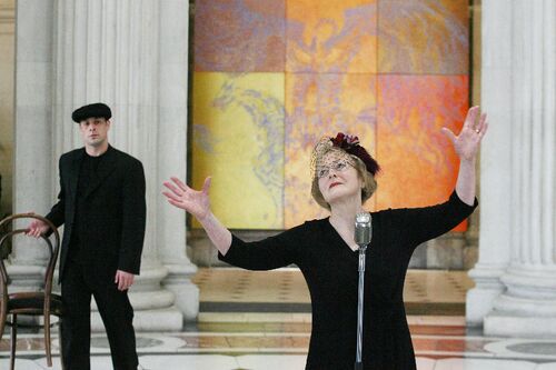 A participant gesturing behind an old fashioned microphone in City Hall