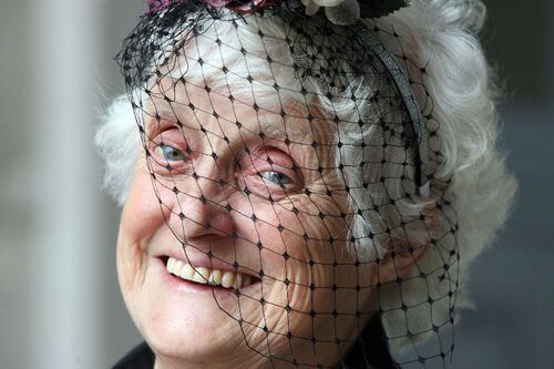 A close up of a participant smiling with a net veil over her face