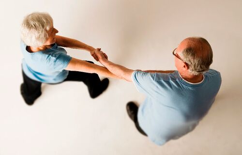 Two figures in movement together with hands clasped together