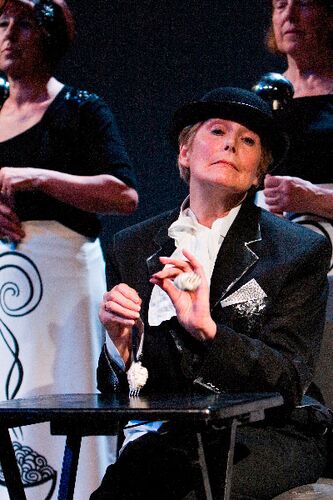 A close up of a participant seated at a table making two forks dance like legs