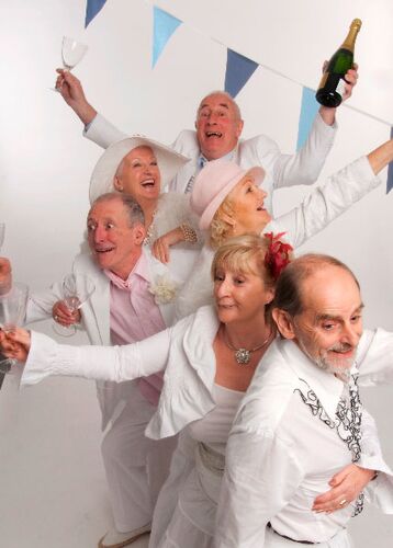A line of participants holding champagne glasses and bottles with blue bunting behind them
