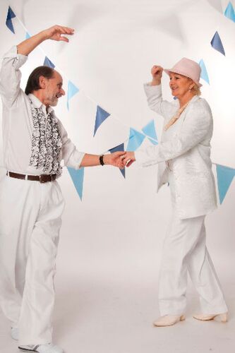 Two participants dancing together holding one hand with the other raised up