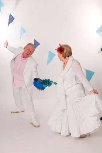 Two participants all in white in movement with blue bunting behind
