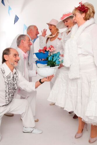 Two lines of participants with one line offering flowers inside upturned helmets to the other