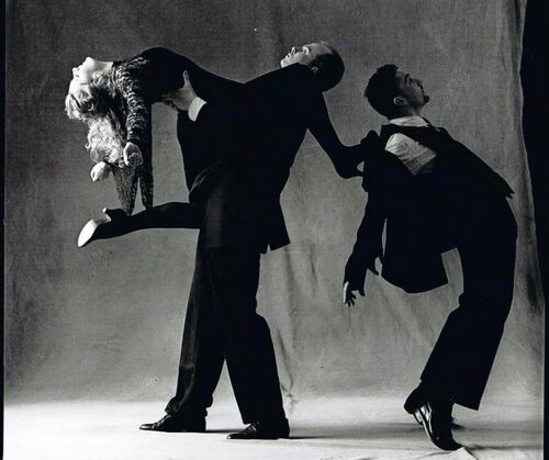 Three figures in movement in a photo studio in black and white