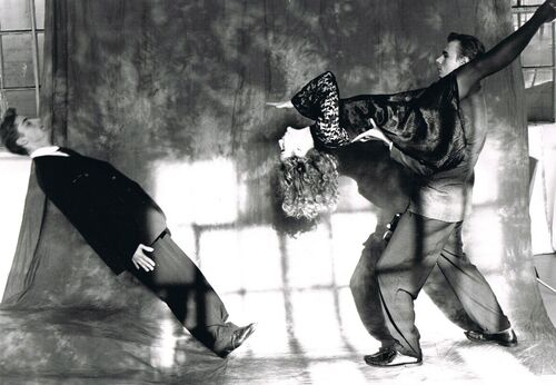 Two figures mid-lift facing another tilting backwards in a fall