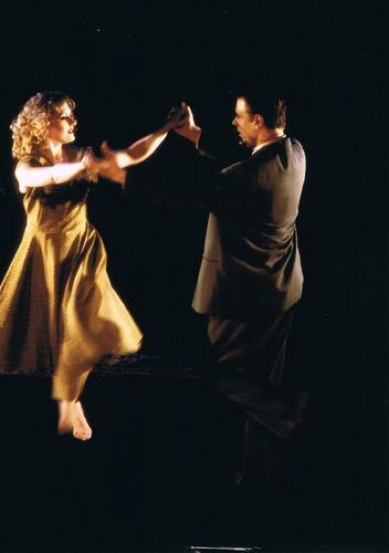 Two figures dancing together with hands held